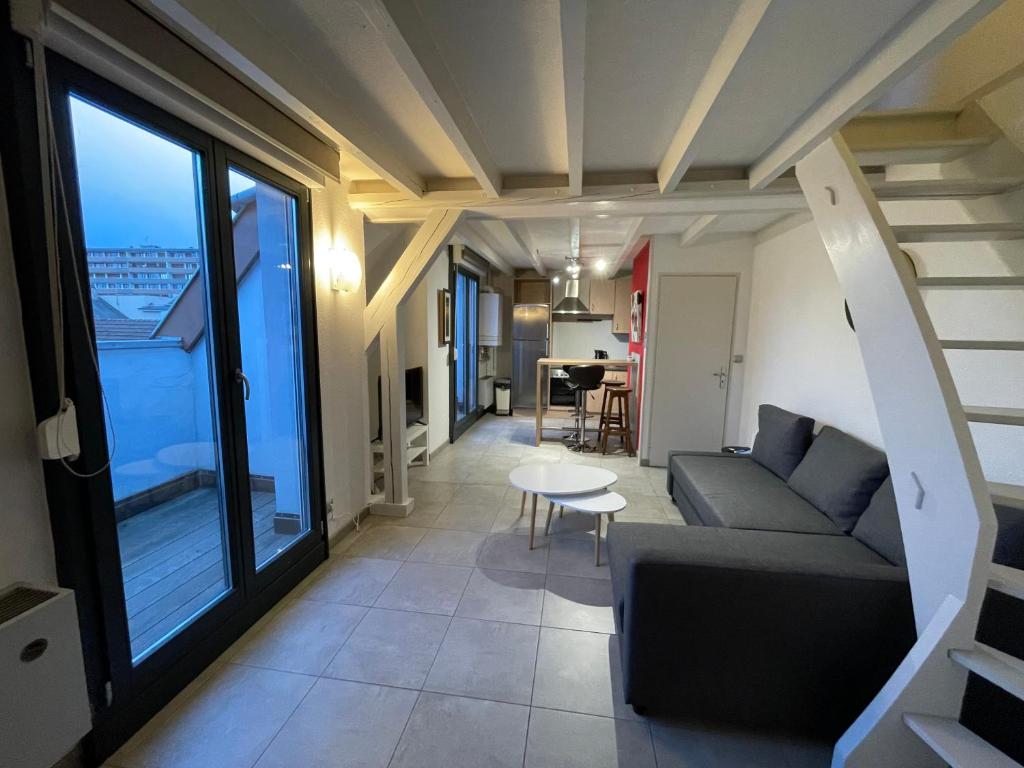 萨尔堡FATHALA - appartement lumineux en dernier étage - face à la gare routière的客厅配有沙发和桌子