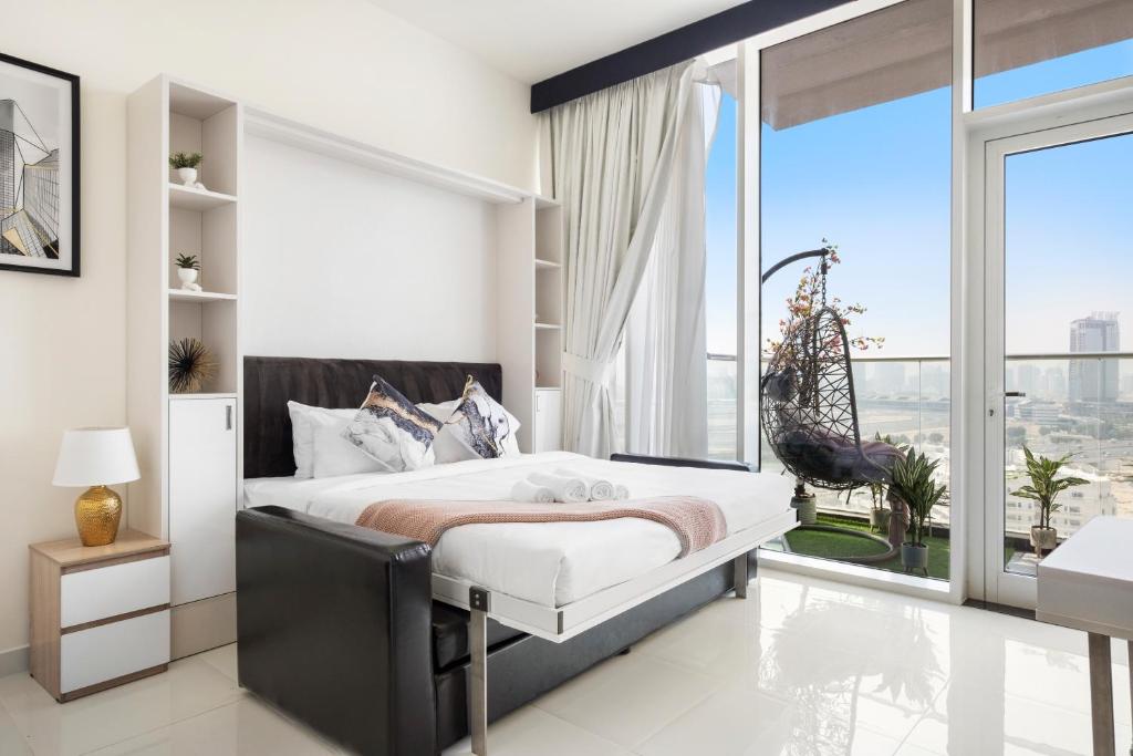 迪拜Modern Studio in Arjan-Dubailand的一间卧室设有一张床和一个大窗户