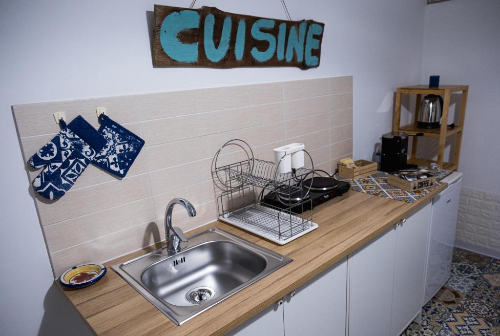 阿格里真托心灵圣殿公寓的厨房柜台设有水槽和阅读美食的标志