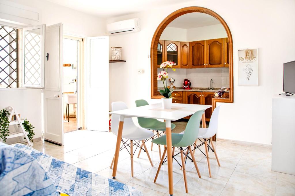 托雷莫泽Casa Tridente - Meravigliosa villa sul mare的厨房以及带白色桌椅的用餐室。
