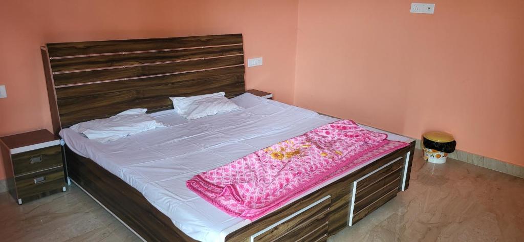 AyodhyaUtsav Vatika的卧室内的一张带木制床头板的大床