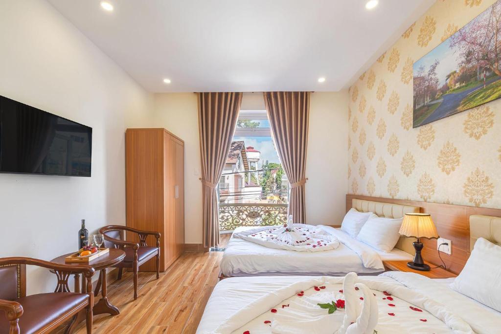 大叻Villa Hoa Ly Đà Lạt的酒店客房设有两张床和电视。