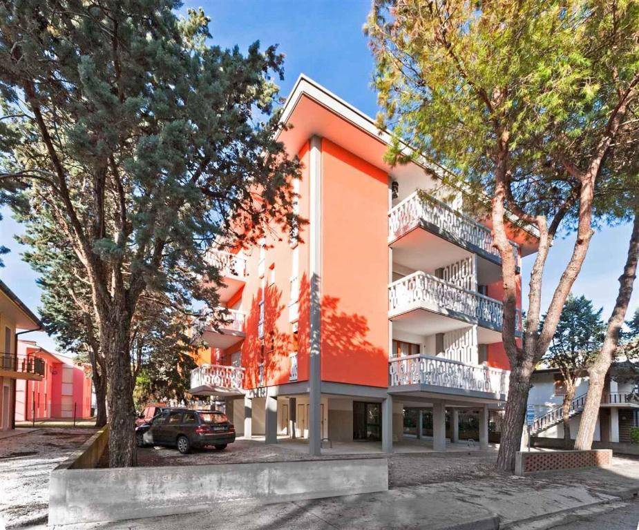 比比翁Apartment in Bibione 24409的一座橘色的建筑,前面有树木