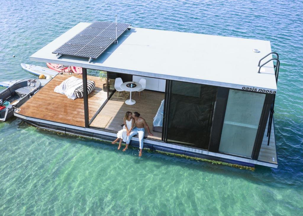 努萨角oasis noosa - luxury floating eco villas的两个人坐在水中船的背上