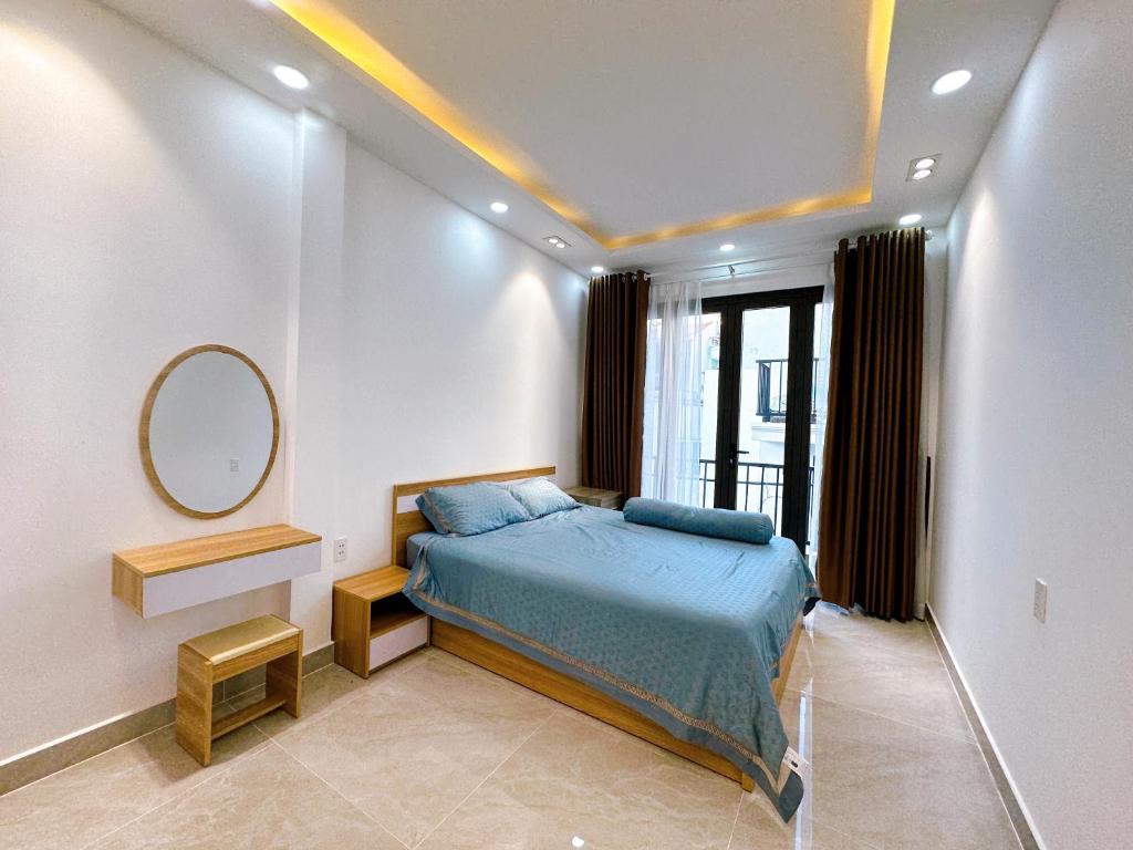 胡志明市Alley Homestay Sai Gon的卧室配有一张床,墙上设有镜子