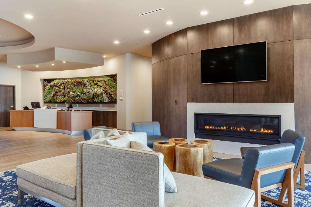 斯波坎Cambria Hotel Spokane Airport的客厅设有壁炉和电视。