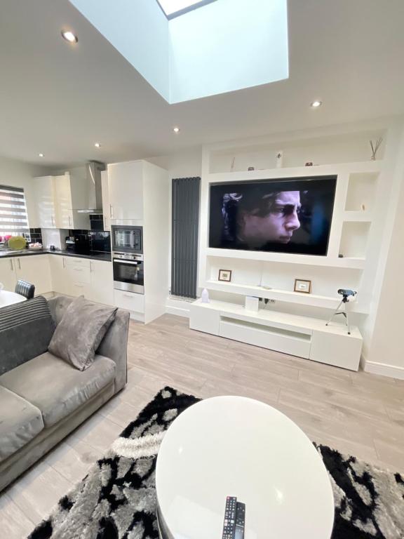 达格纳姆UPPAMOST London luxury home 2的带沙发和电视的客厅