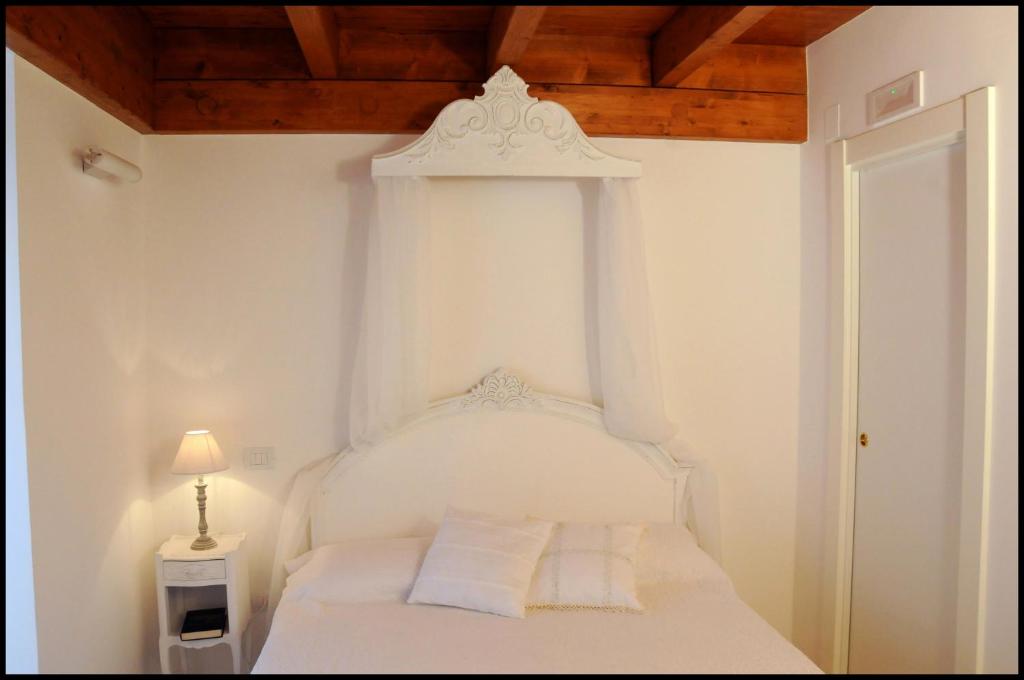 巴列塔B&B Al Vecchio Borgo的卧室配有白色床和木制天花板