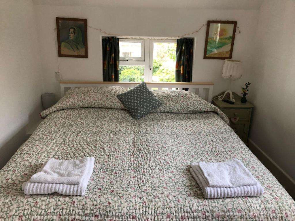 布里德波特Barn Corner的一间卧室配有一张床,上面有两条毛巾