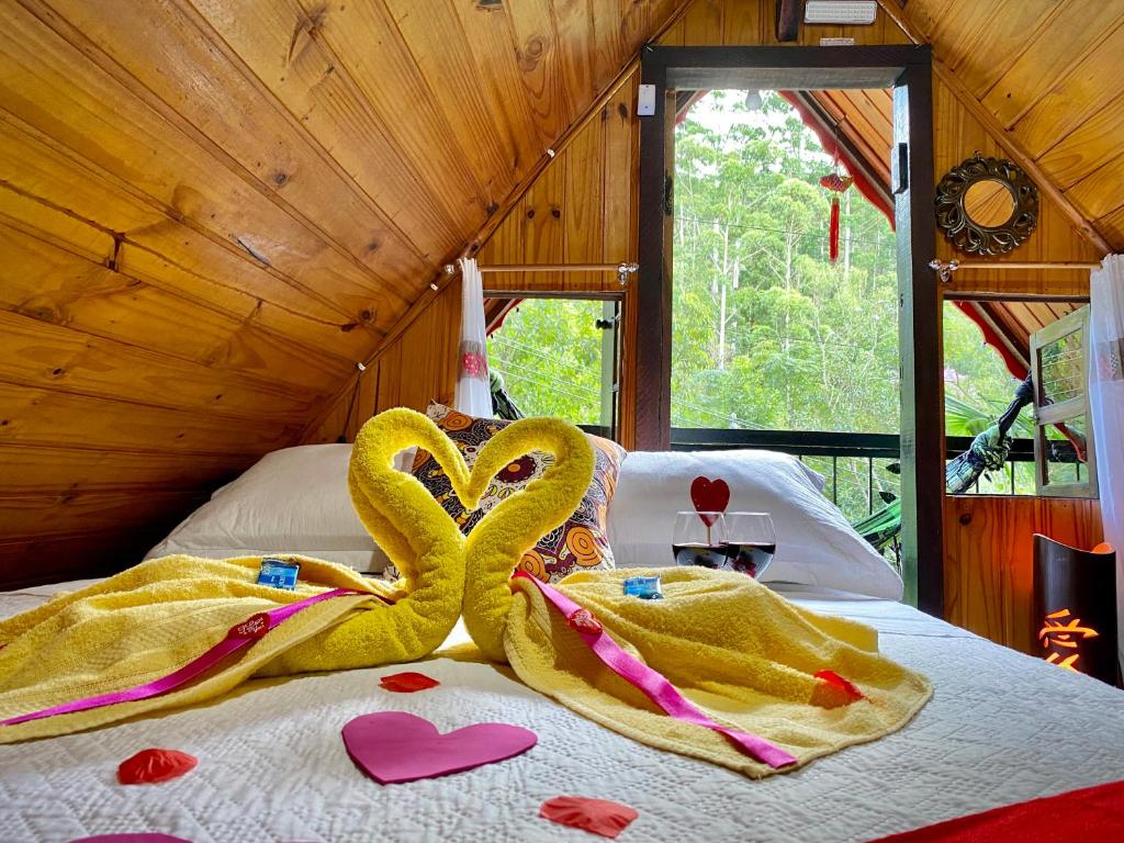 维奥康德马奥Alto na Montanha Chalé 1的床上用毛巾制成的两天鹅