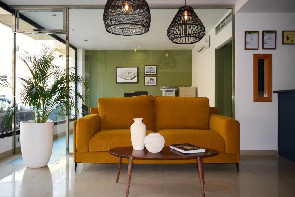 阿瓜杜尔塞Hotel Mirablau的客厅配有黄色的沙发和桌子