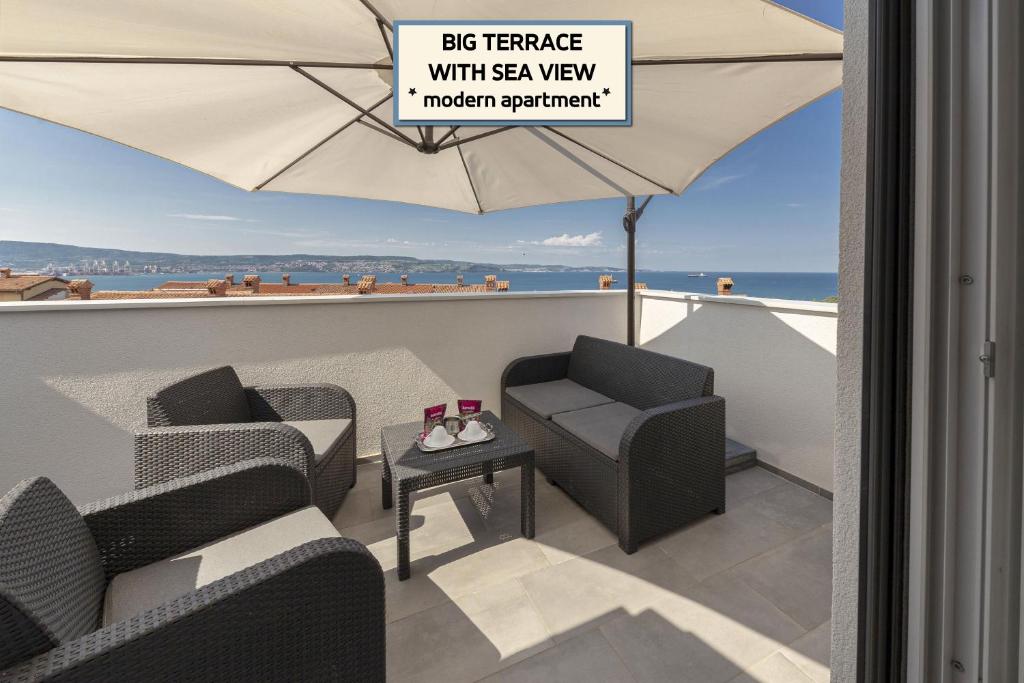 安卡兰Apartments ERA Ankaran的阳台配有两把椅子和一把伞