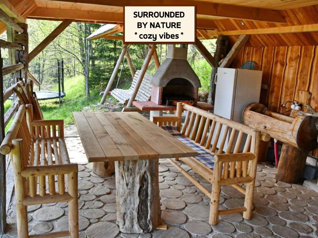 佐尔尼耶戈迪APARTMA JAKOPIČ的小屋内一张木桌和椅子,配有壁炉