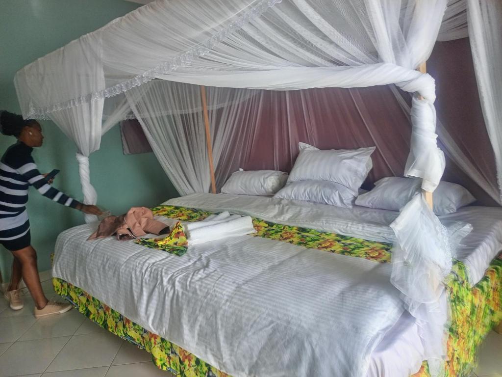 卡巴莱African Tent Resort的一位女士站在一张大床旁边
