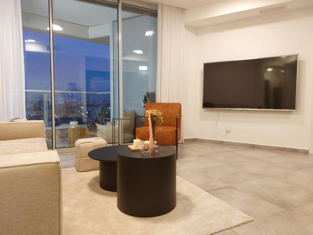 特拉维夫Gindi Tower Apartments TLV的带沙发、桌子和电视的客厅