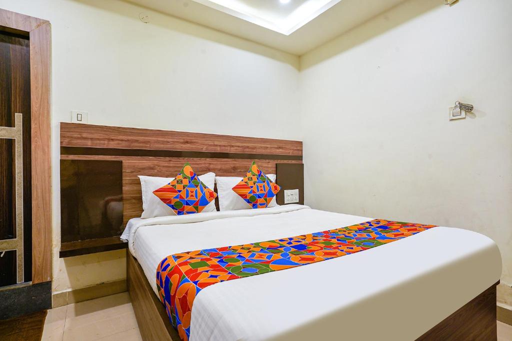 维杰亚瓦达FabHotel Raj Vihar Residency的一间卧室配有一张大床和色彩缤纷的毯子