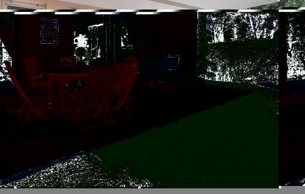 圣拉斐尔Nice Apartment In Saint Raphael With Outdoor Swimming Pool的黑暗的客房配有椅子和一张绿光桌子