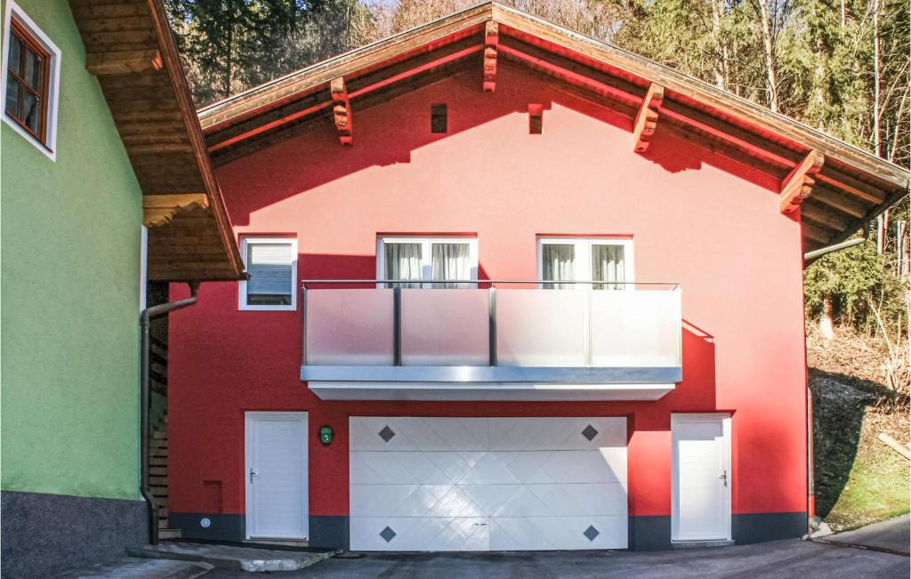 上柯尼希山麓米尔巴赫Beautiful Apartment In Mhlbach Am Hochknig With Kitchen的一间红色的房子,旁边设有阳台