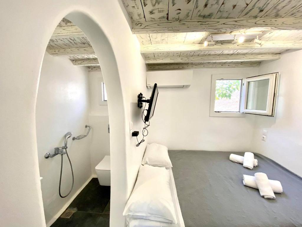 AggelikaMYKONOS VIBES AIRPORT STUDIOS AND APARTMENTS的一间带淋浴的浴室和一张长凳