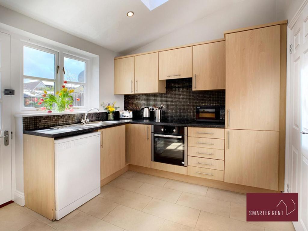 阿斯科特Ascot - Immaculate 2 bed House with parking的厨房配有木制橱柜和窗户。