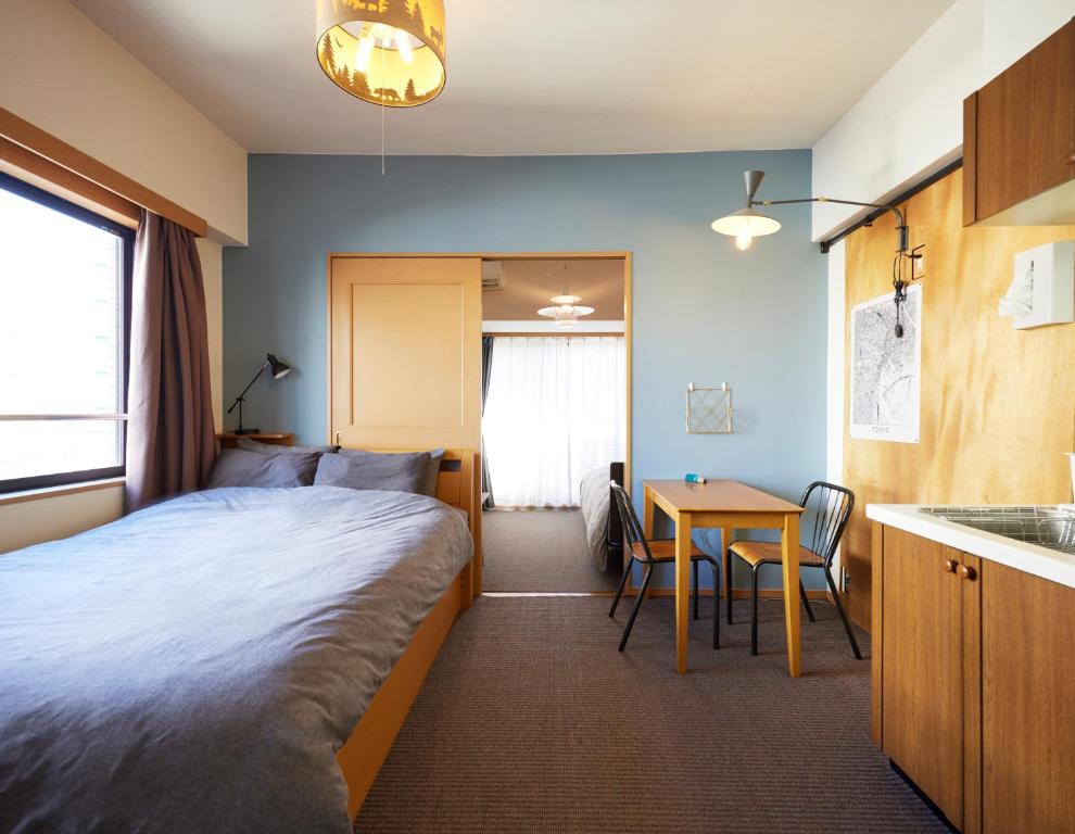 东京Shibuya apartment SHINSEN的酒店客房配有一张床铺和一张桌子。