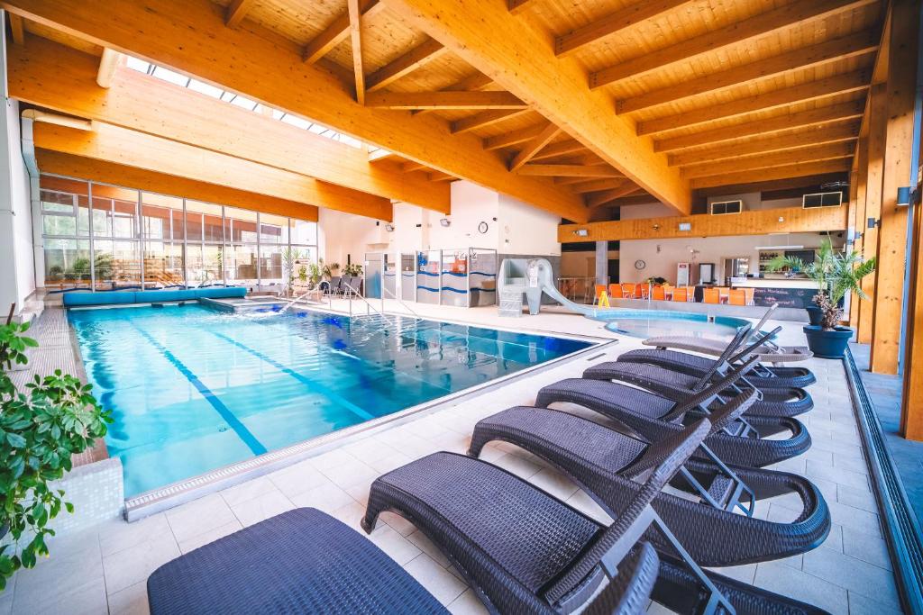 ČertovWellness & Spa Hotel Čertov的旁边设有一排椅子的大型游泳池