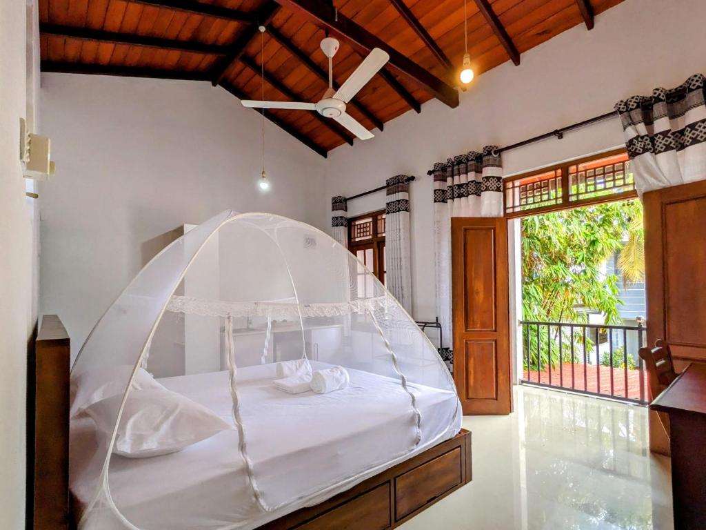 坦加拉Lavish Lodge, Tangalle, Sri Lanka的一张白色天蓬床