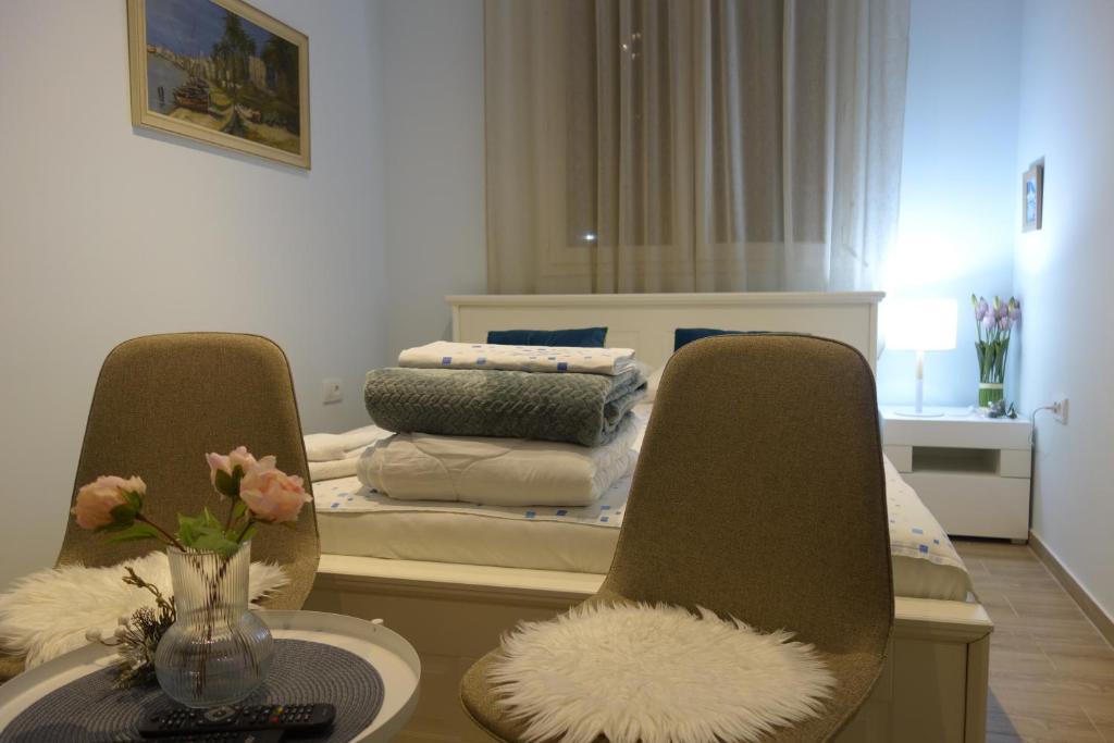 贝尔格莱德Villa Loop Beograd的一间设有两把椅子和一张桌子的床的房间