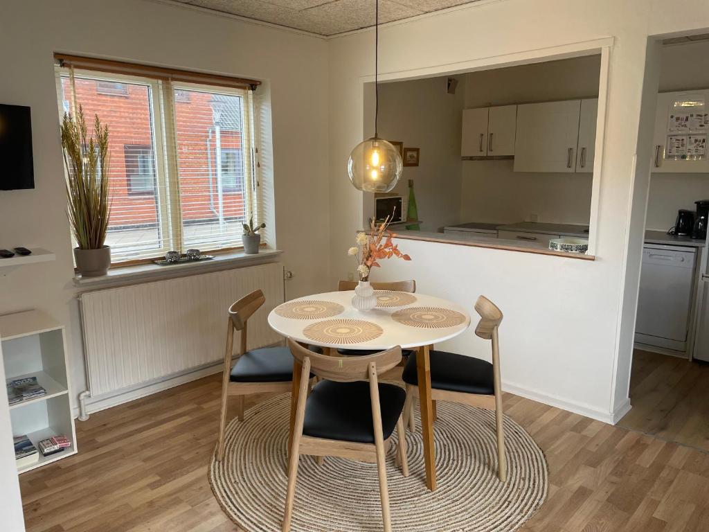斯凯恩Skjernaa-ferie/ Andersen Invest的厨房以及带桌椅的用餐室。