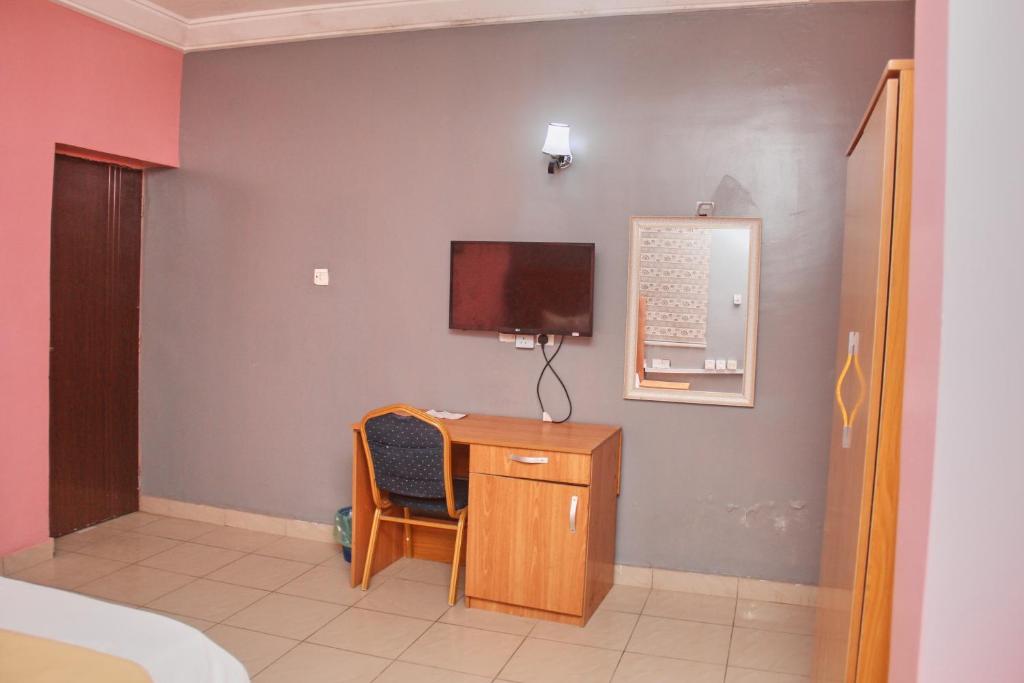 阿布贾GLAMOUR PARK'S HOTEL, ABUJA的客房设有书桌和墙上的电视