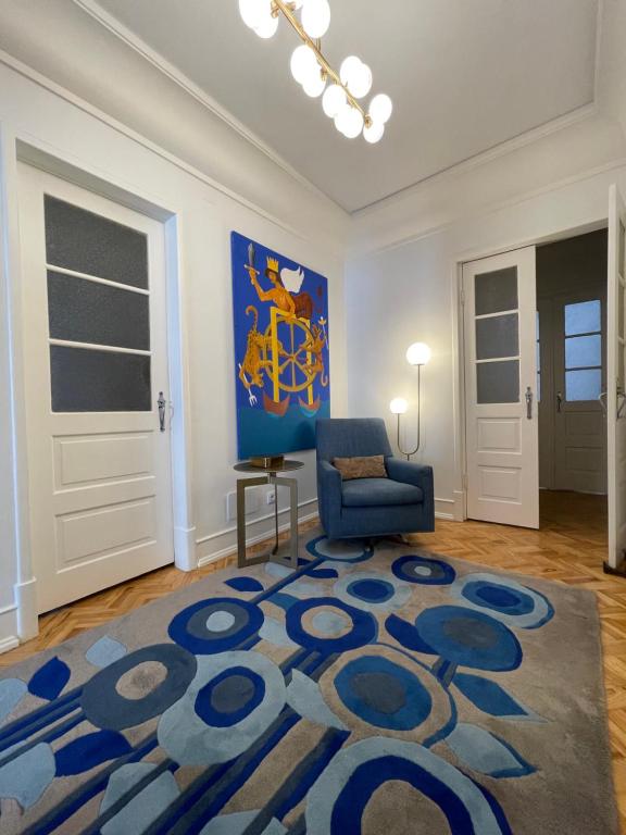 里斯本Suite's Vintage的客厅配有蓝色椅子和蓝色地毯