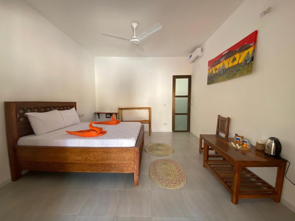帕杰Amani Hotel Paje的一间卧室配有一张带橙色毛巾的床