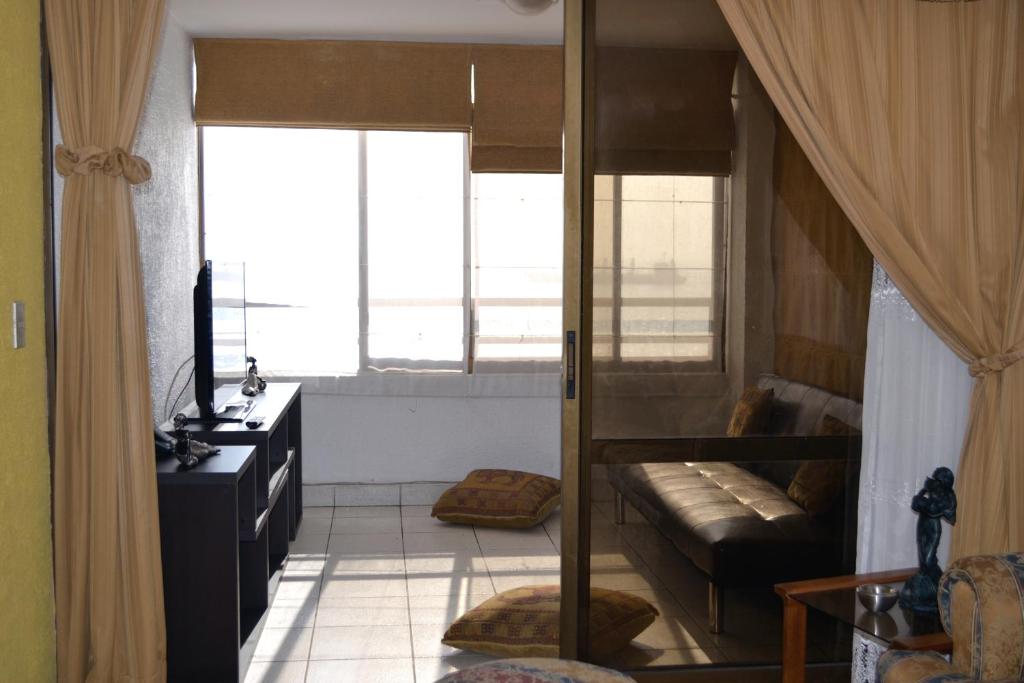 安托法加斯塔格雷西亚大道爱蒙布拉多公寓的客厅配有双层床和沙发。