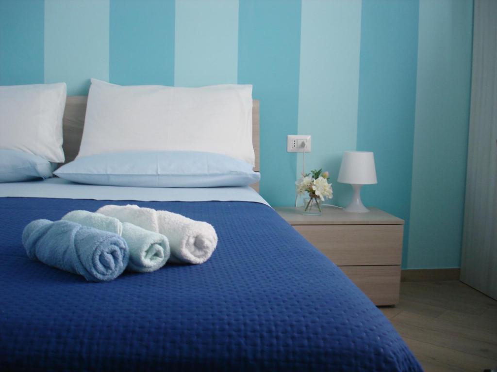 卡梅罗塔码头B&B Margherita的一间卧室配有蓝色的床和毛巾