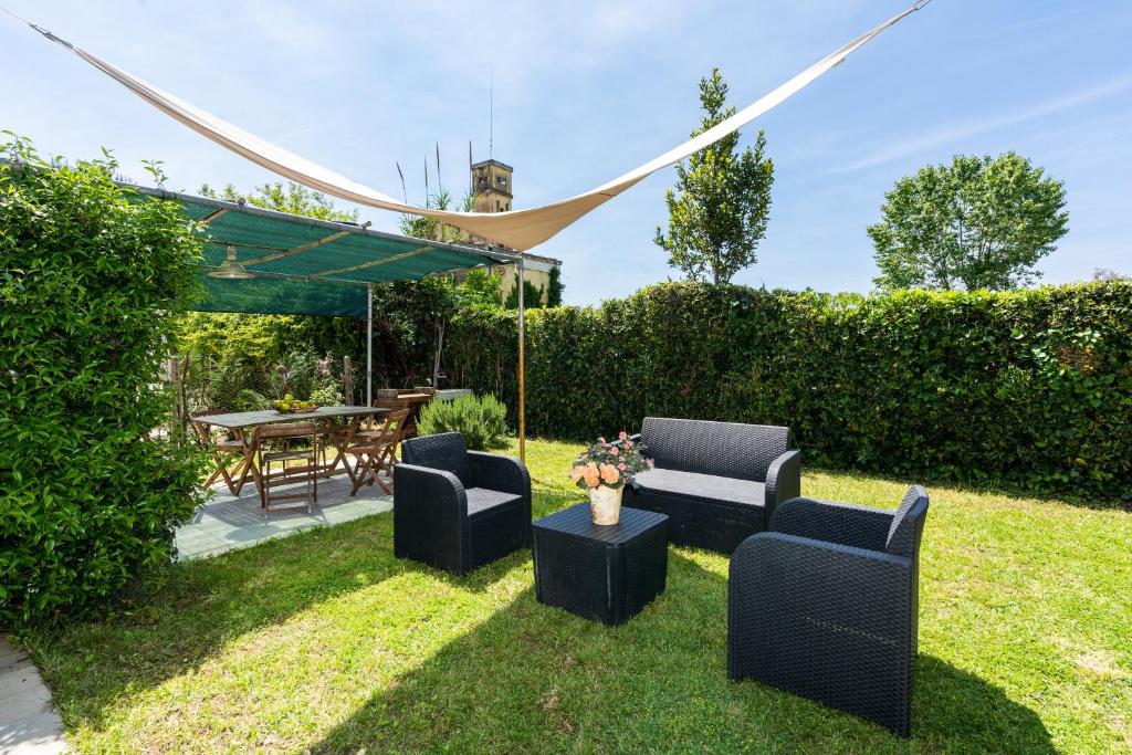 马里纳-迪-皮特拉桑塔Beach House with private garden的一个带两把椅子和一张桌子的花园和一个帐篷
