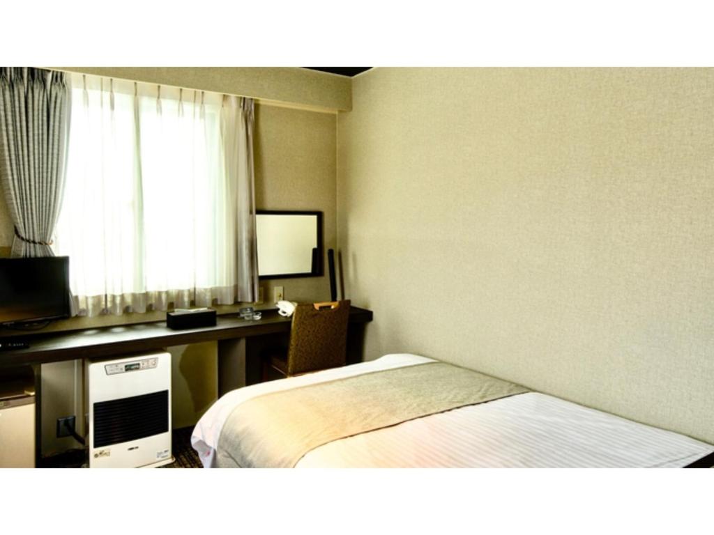 俱知安町Hotel Three M - Vacation STAY 93397v的配有一张床和一张书桌的酒店客房