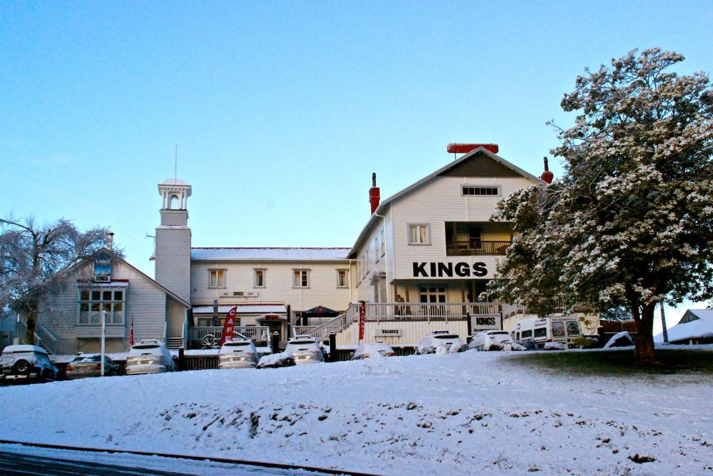 奥阿库尼国王奥阿库尼酒店的一座白色的大建筑,汽车停在雪中