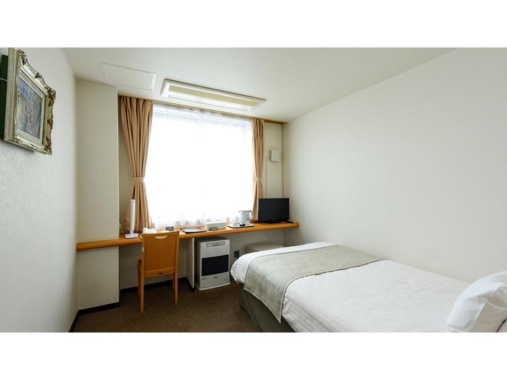 俱知安町Hotel Three M - Vacation STAY 93399v的客房设有两张床、一张桌子和一个窗户。