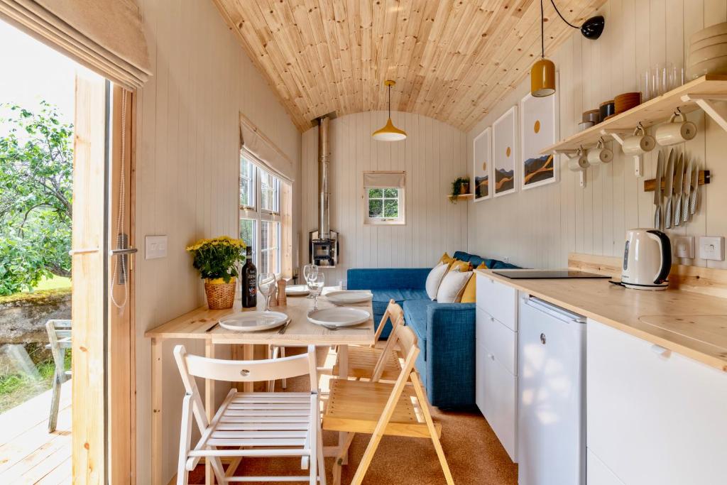 巴拉特Enchanting Tiny House with wood burner and hot tub in Cairngorms的厨房以及带桌椅的用餐室。