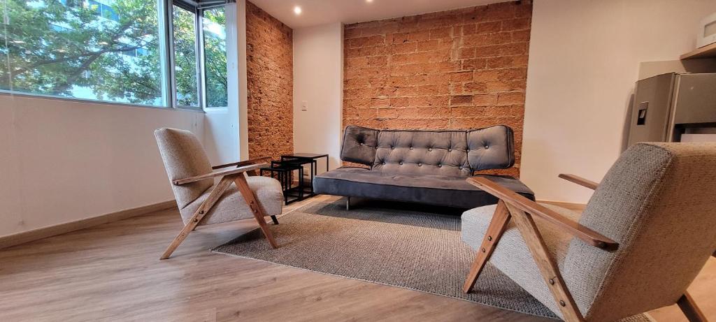 波哥大玛格丽塔公寓的客厅配有沙发和两把椅子