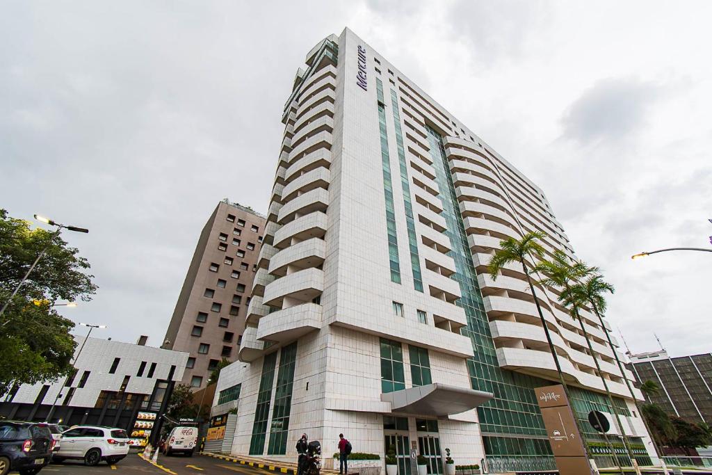 巴西利亚GS Properties - Hotel Líder的一条城市街道上高大的白色建筑