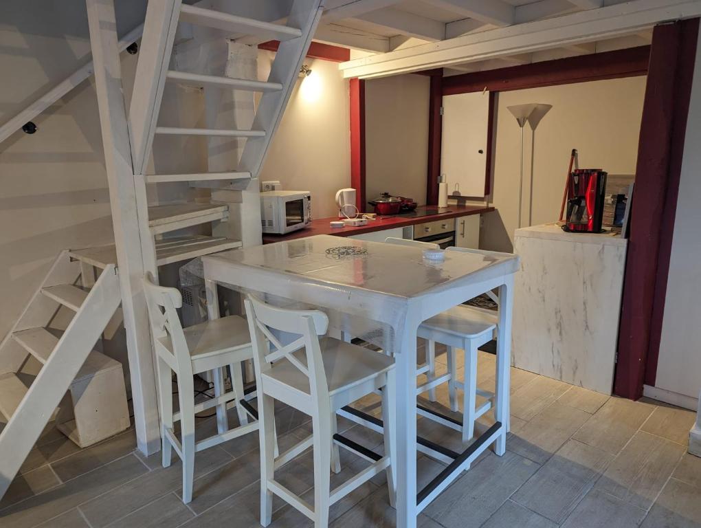 Livarotcharmante maison Normande的厨房配有白色的桌子和白色的凳子