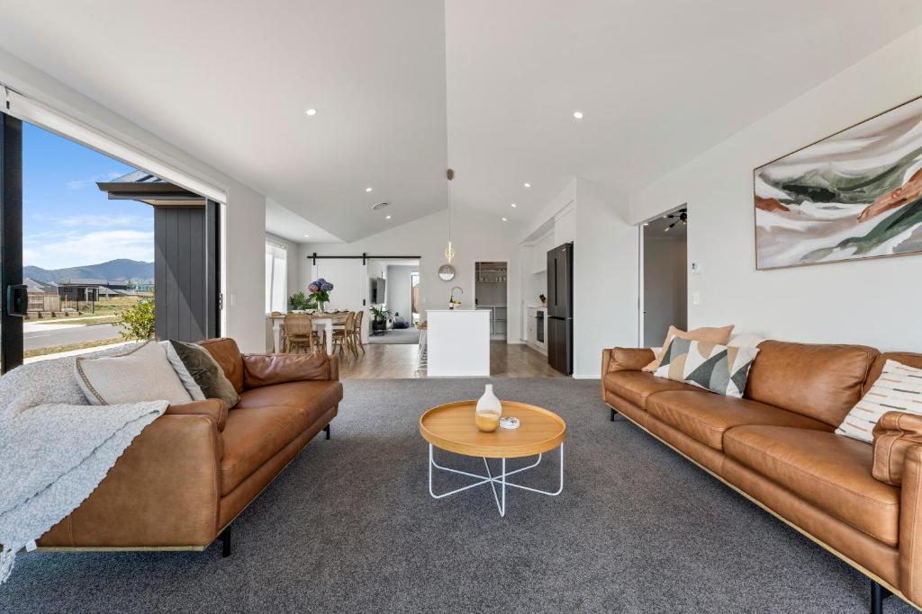 陶波Harakeke Holiday Haven - Taupo的客厅配有2张棕色沙发和1张桌子