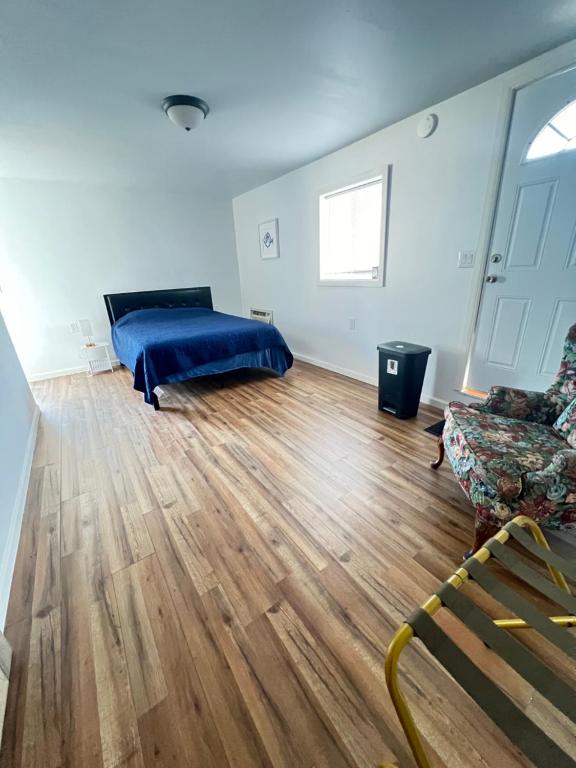 托伦斯LittleBettysCrashPad的一间卧室配有一张床和一张沙发,铺有木地板