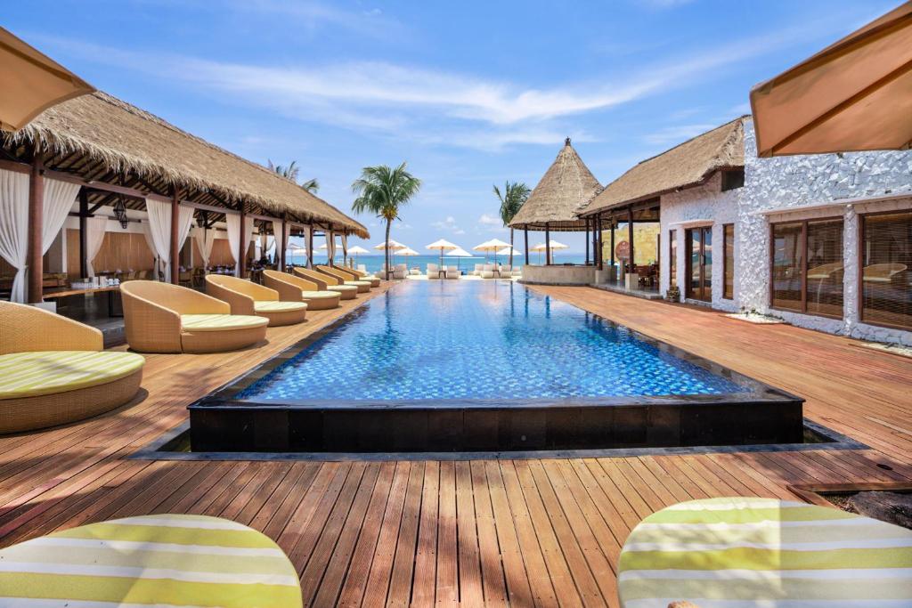 蓝梦岛蓝梦海滩俱乐部和度假酒店的一个带躺椅的游泳池的度假酒店