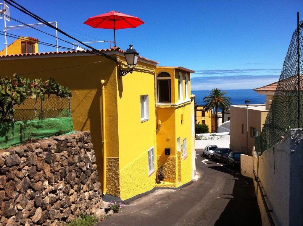 La Guancha多米尼加之家公寓的黄色的建筑,上面有红伞
