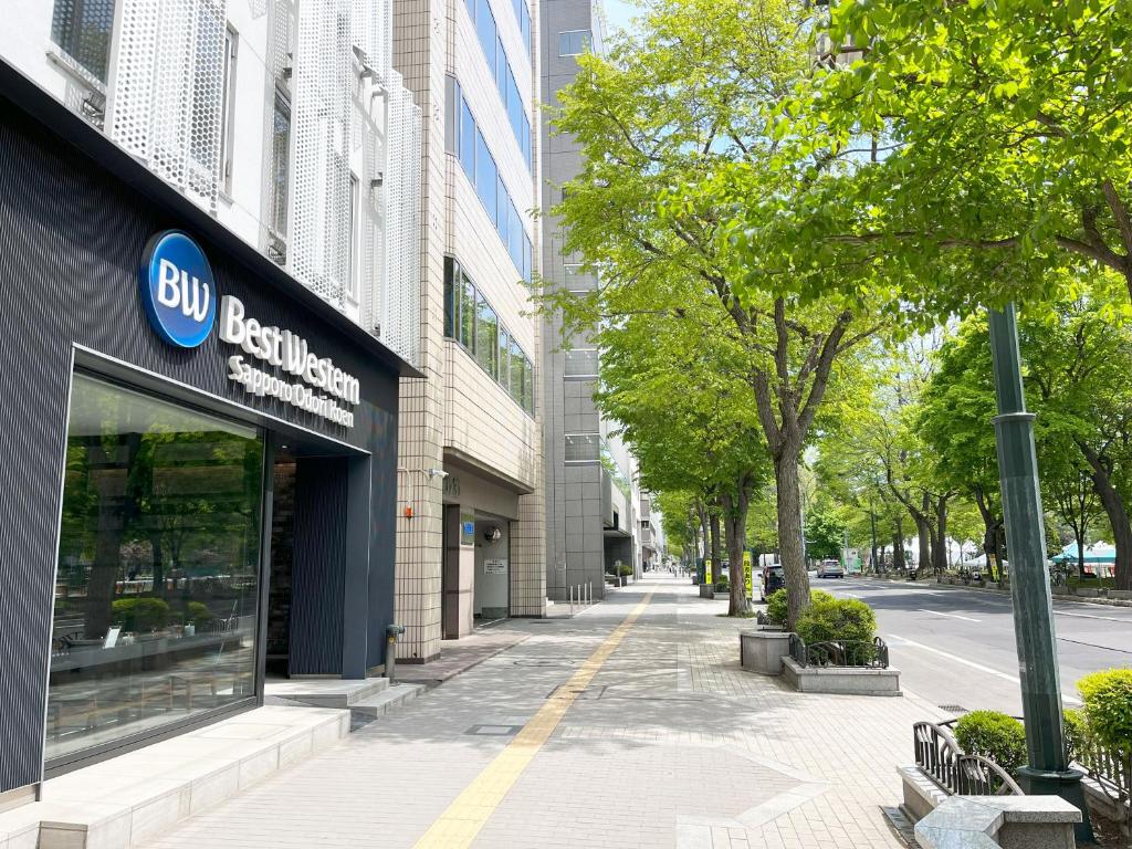 札幌Best Western Sapporo Odori Koen的城市街道上一座有bmw商店的建筑