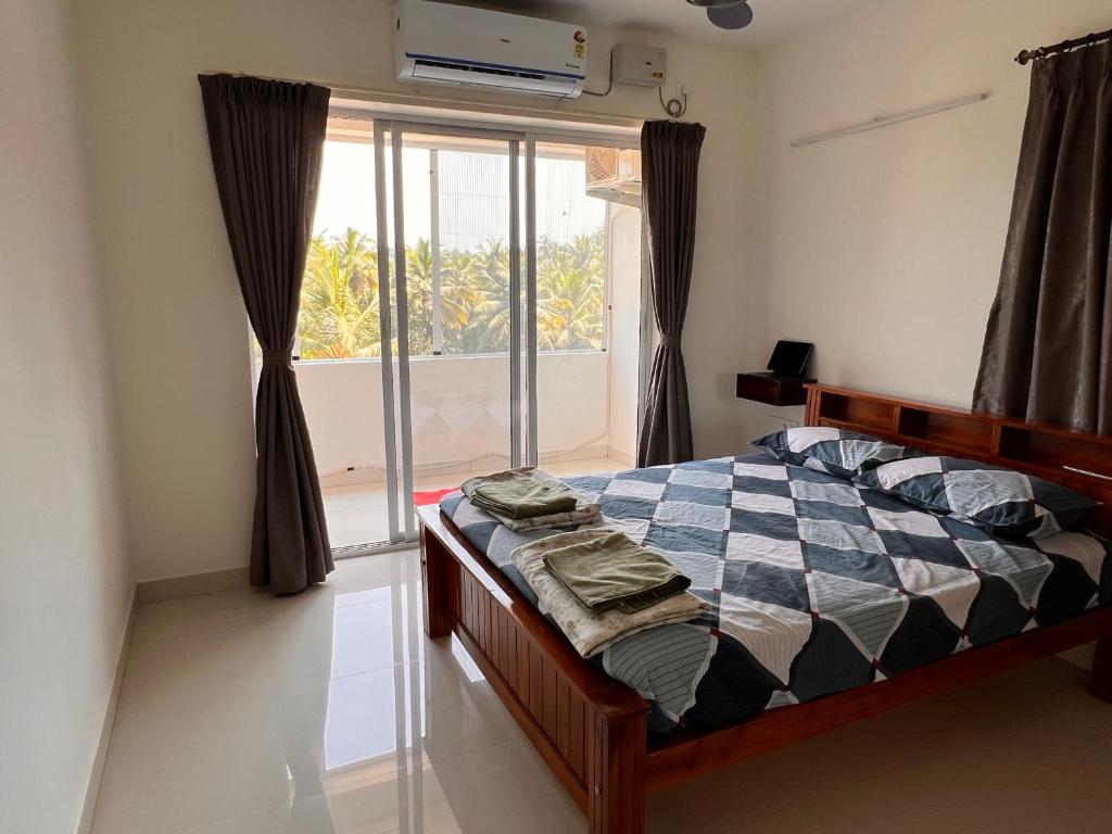 门格洛尔Nirvana Stay, Spacious Fully furnished 2bhk apartment in Mangalore, Full AC的卧室在窗户前配有一张床