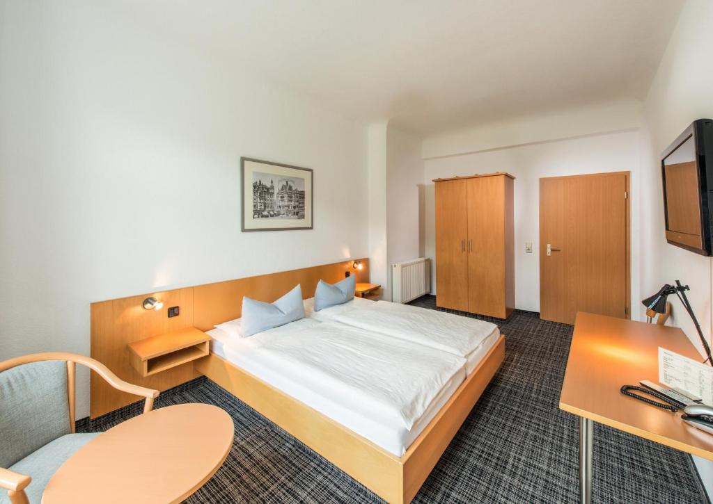 艾森纳赫城市酒店的配有一张床和一张书桌的酒店客房