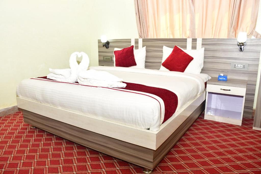 DhangadhiHotel Jiyan Hospitality Pvt. Ltd.的一间卧室配有一张带红色枕头的大床